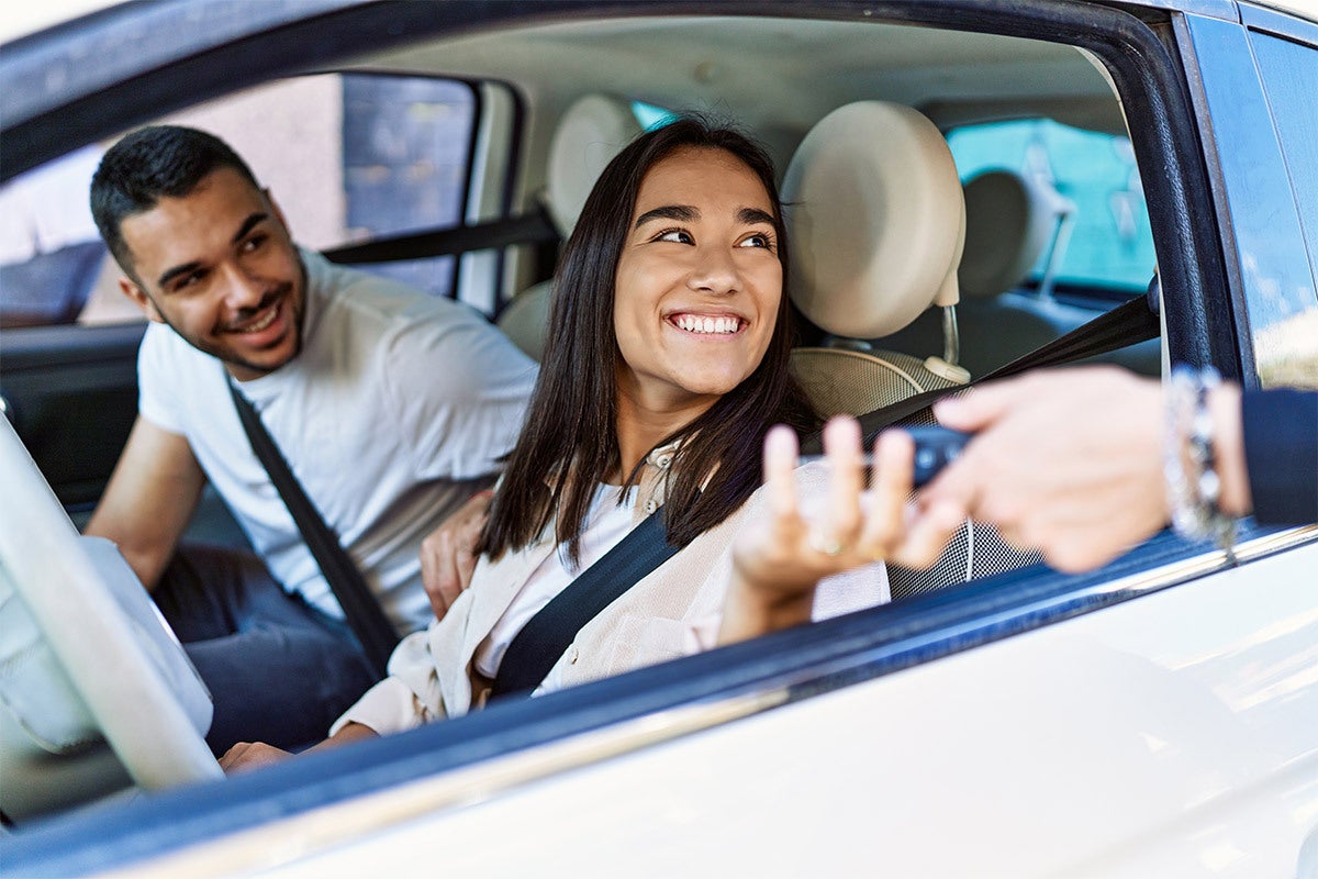 Couple buying a used car at GMC of Watertown